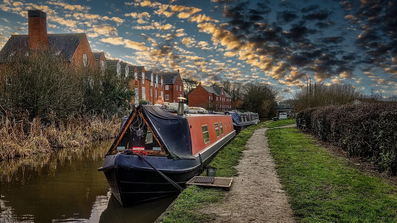 Narrowboats moored along a canal towpath — the Basingstoke Canal runs through Woking